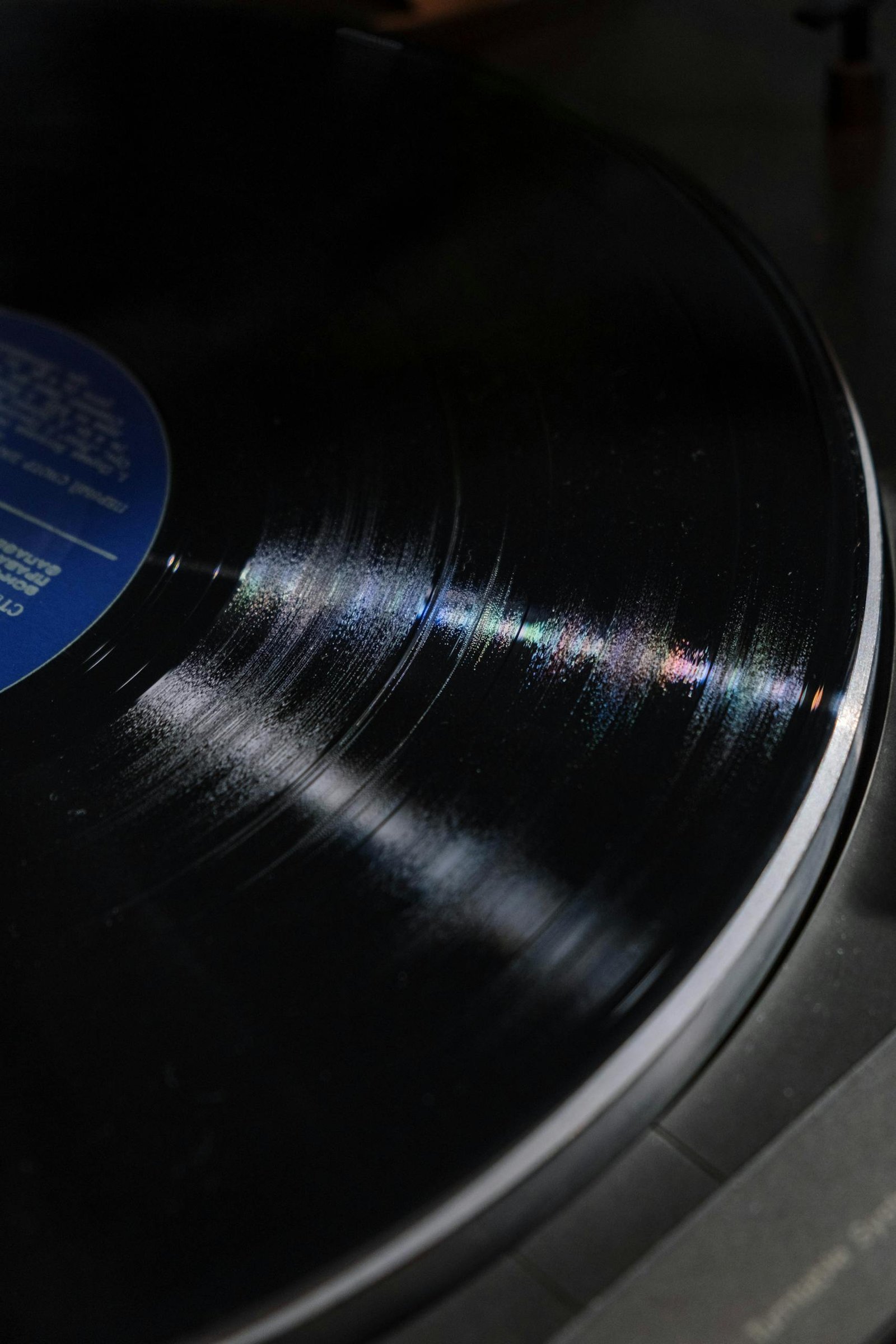 Detailed close-up of a spinning vinyl record showing grooves and reflections.
